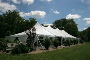 A beautiful high peak tent set up through a garden